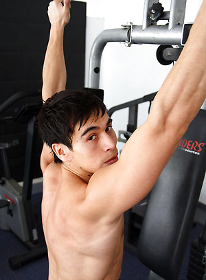 Young jock shows his sixpack in a gym