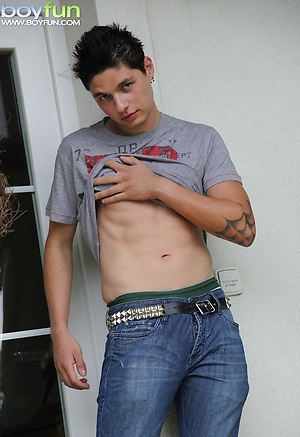 Tattooed stud Jeremy stroking his cock outdoors.