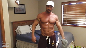 Muscular guy plays with his cock & cums